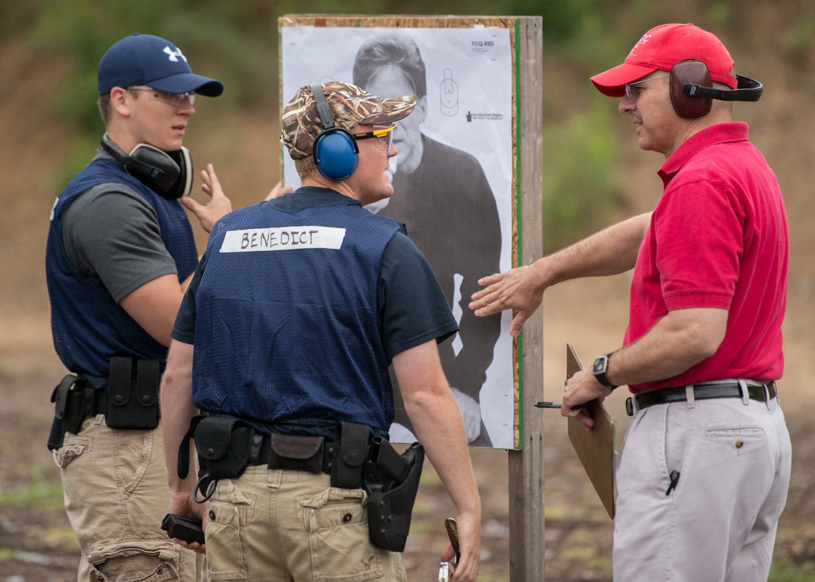 criminal justice faculty in the field at a gun range with students