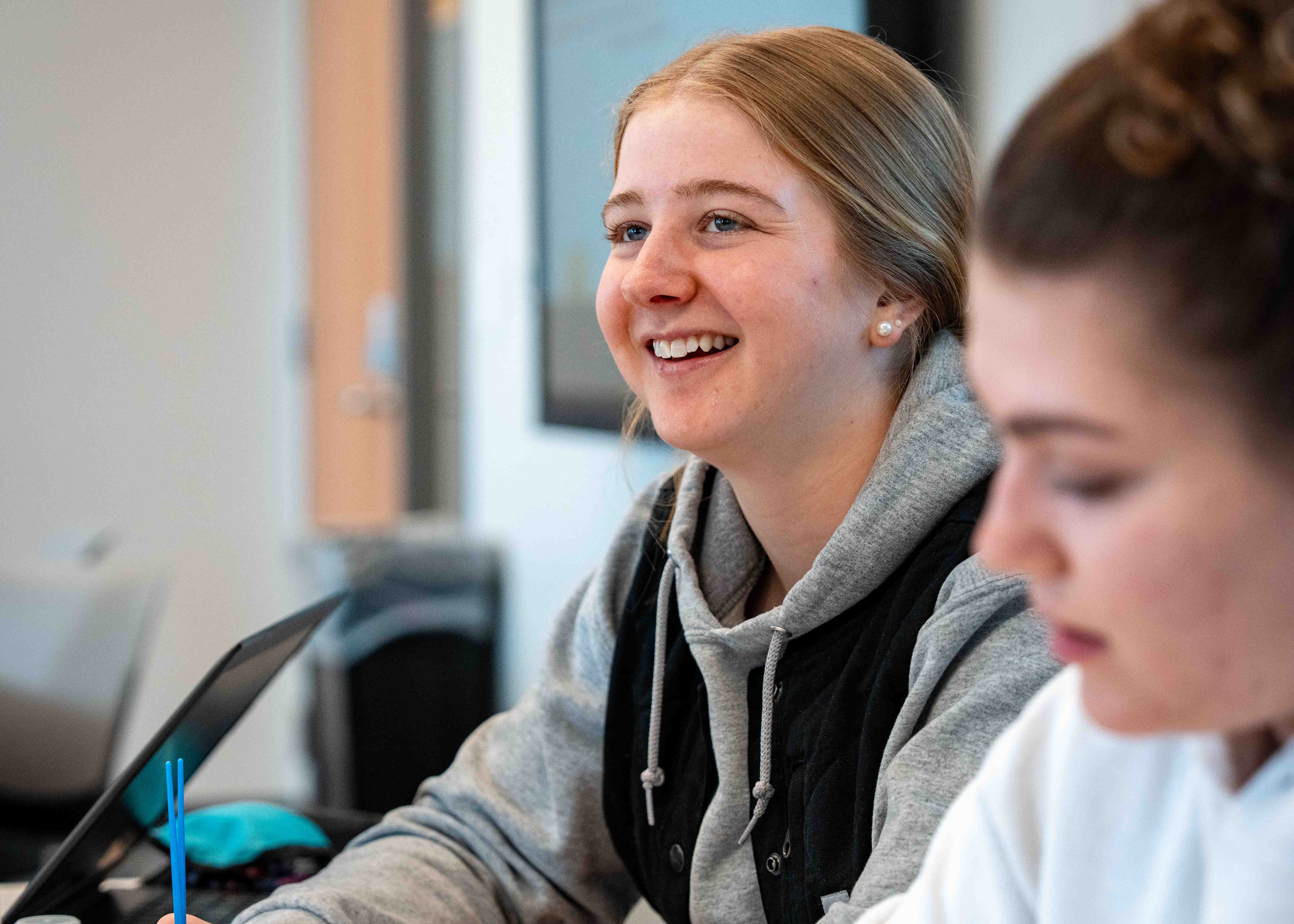 student in a classroom smiling