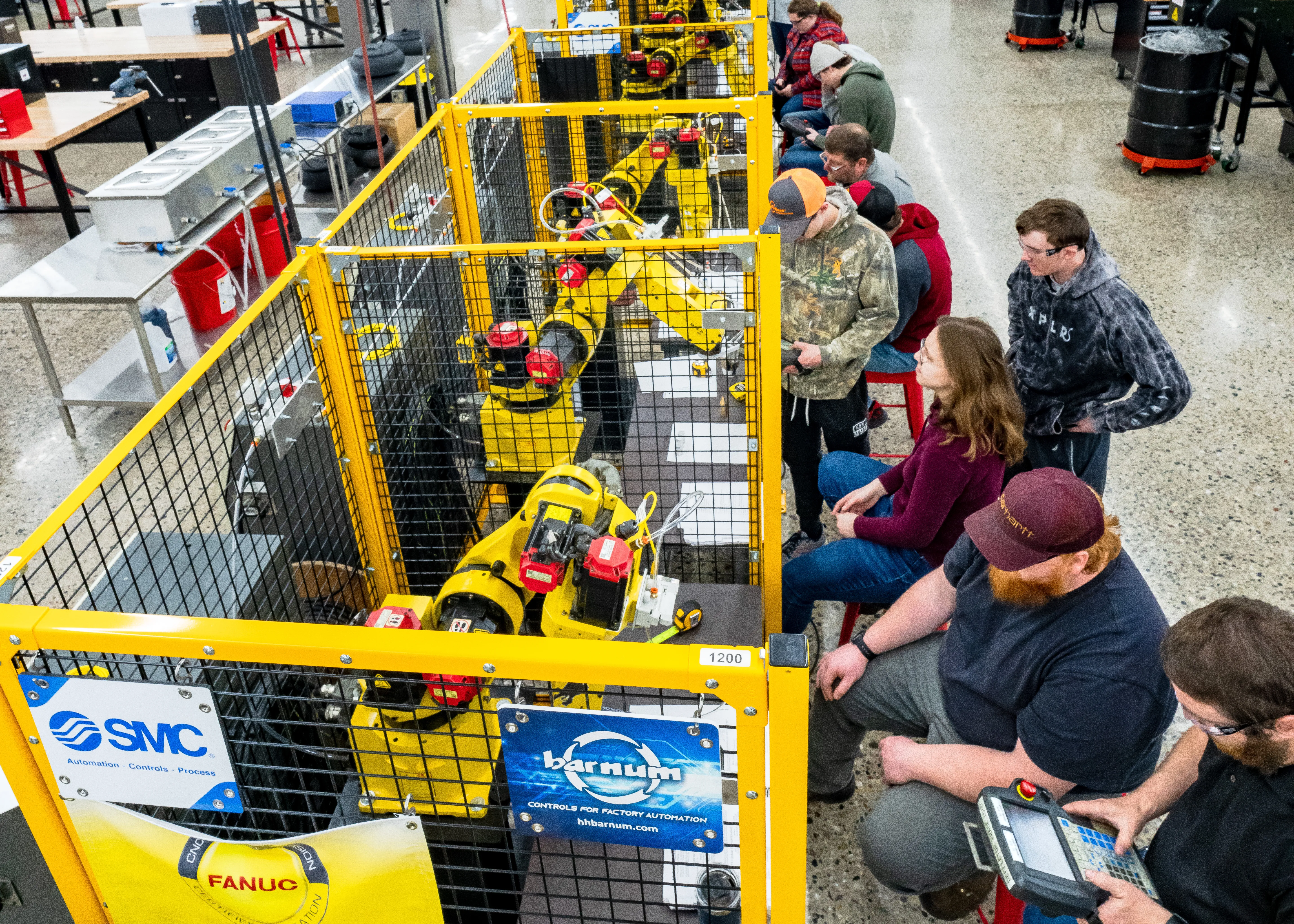 students working with programming robots in a large warehouse
