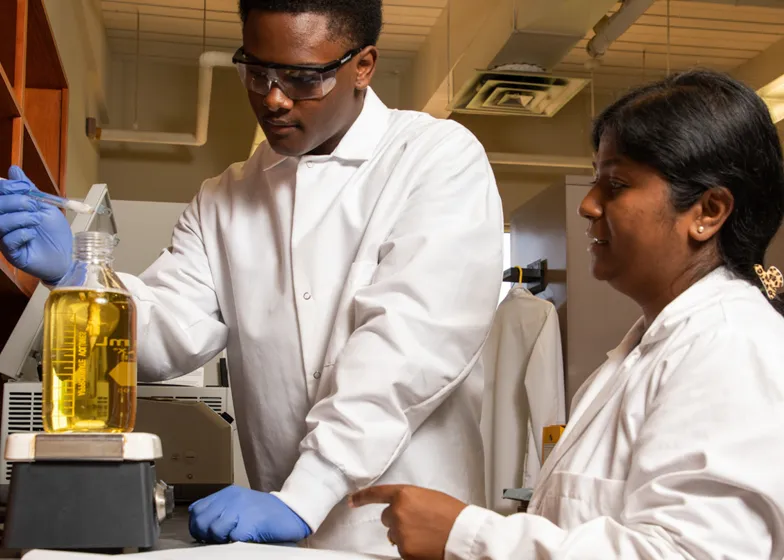 Students working in a chemical manufacturing lab setting