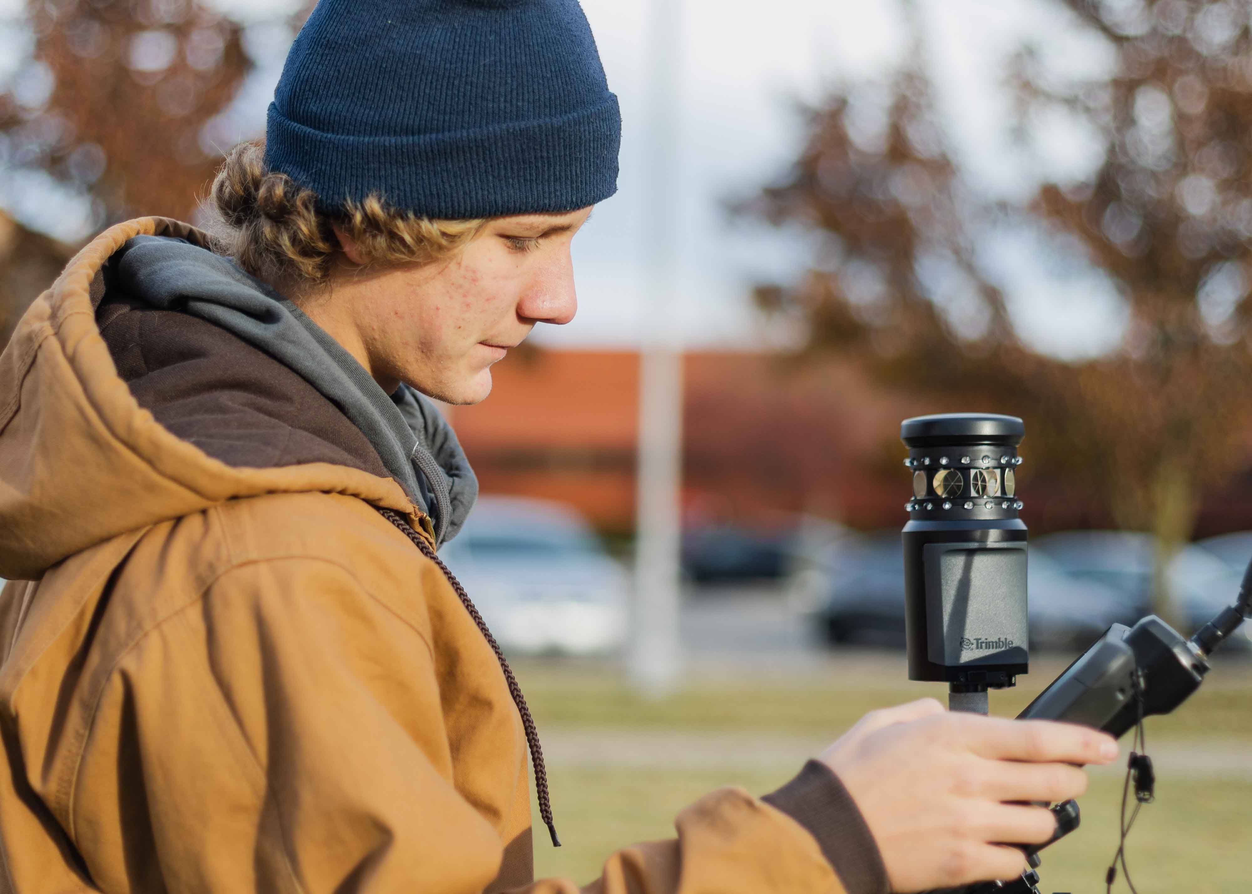 student using surveying engineering equipment