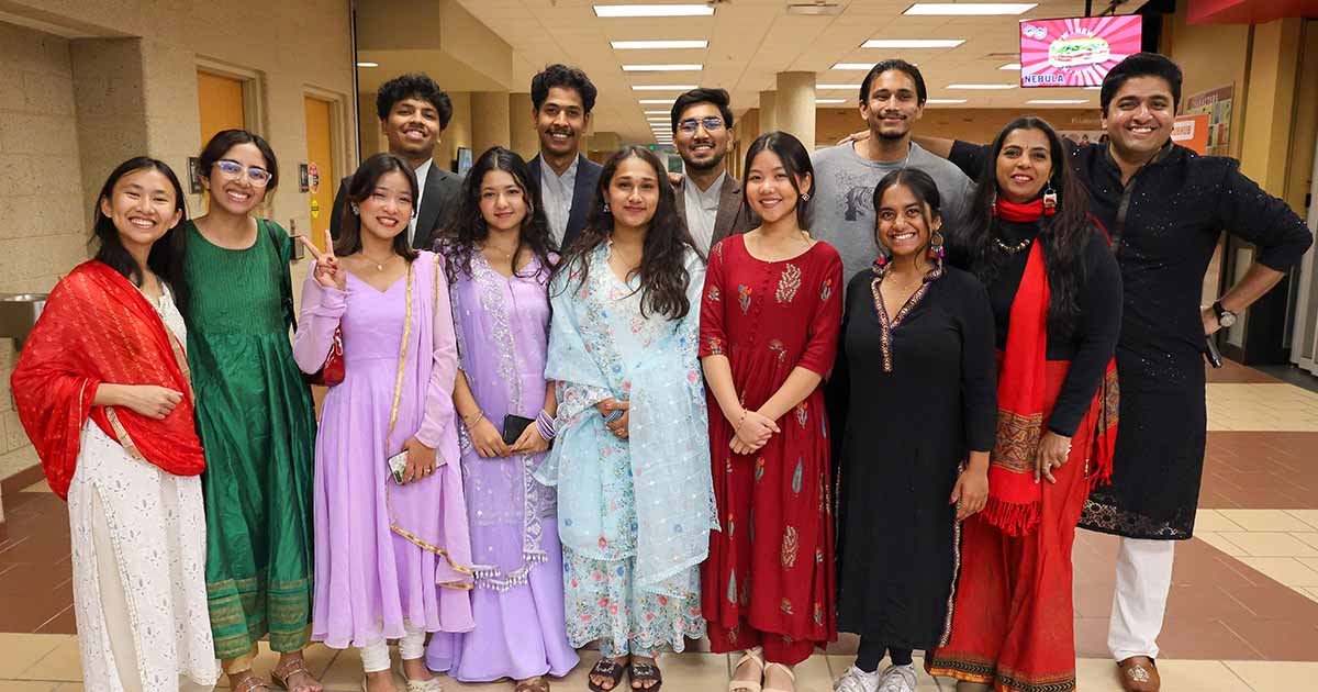 A group of Ferris State University international students at a culture event wearing various traditional cultural clothing.