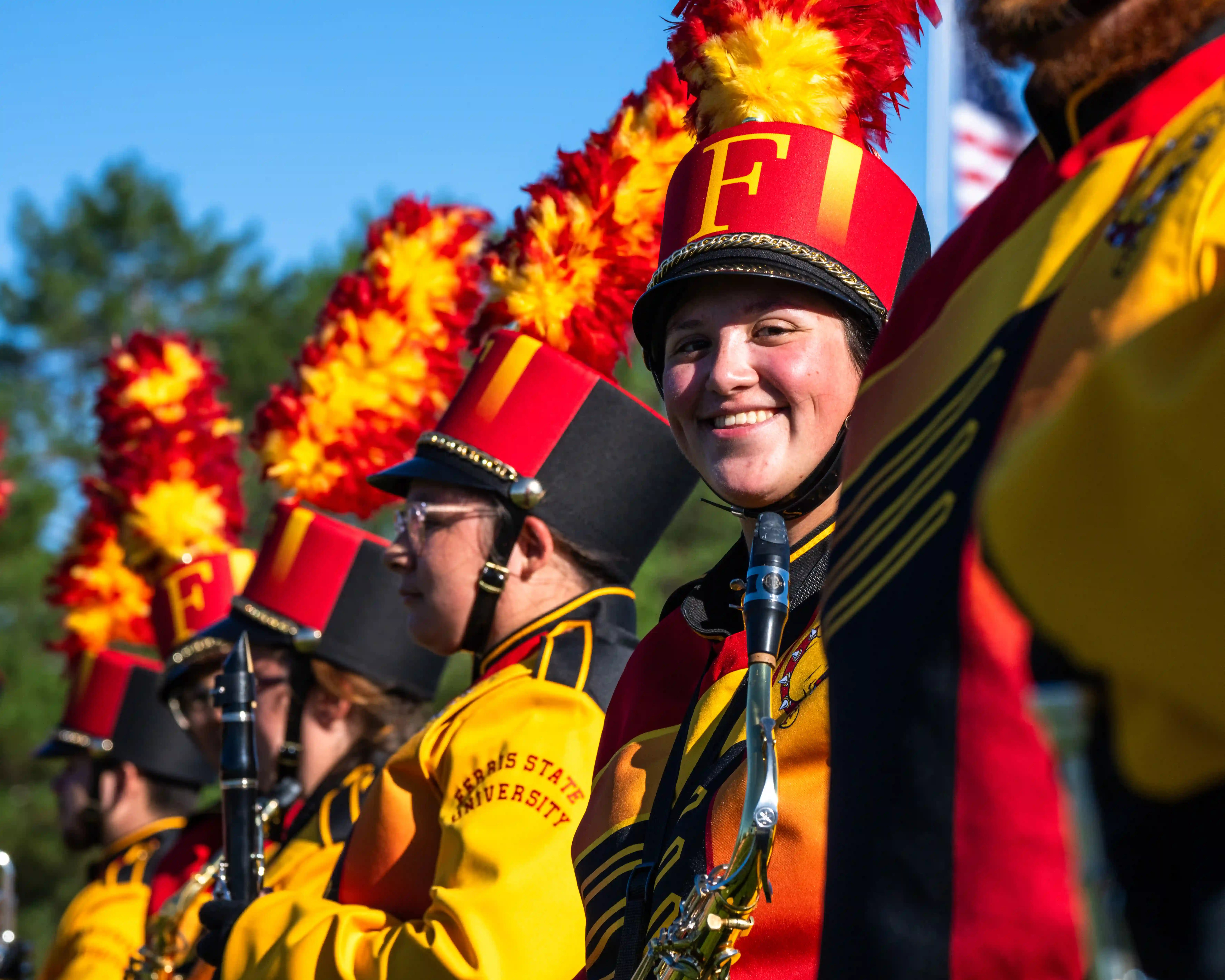 student smiling holding a saxophone