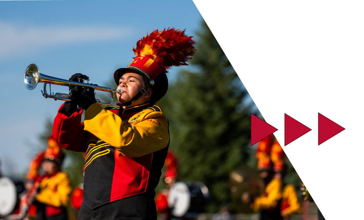 Marching band student playing a trumpet while performing at halftime