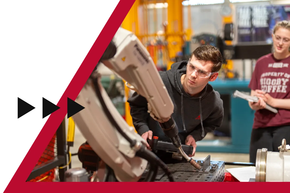 Ferris State students working with an industrial robot