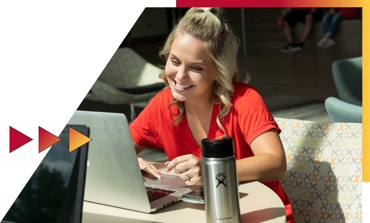 Student on the campus of Ferris State University using a computer