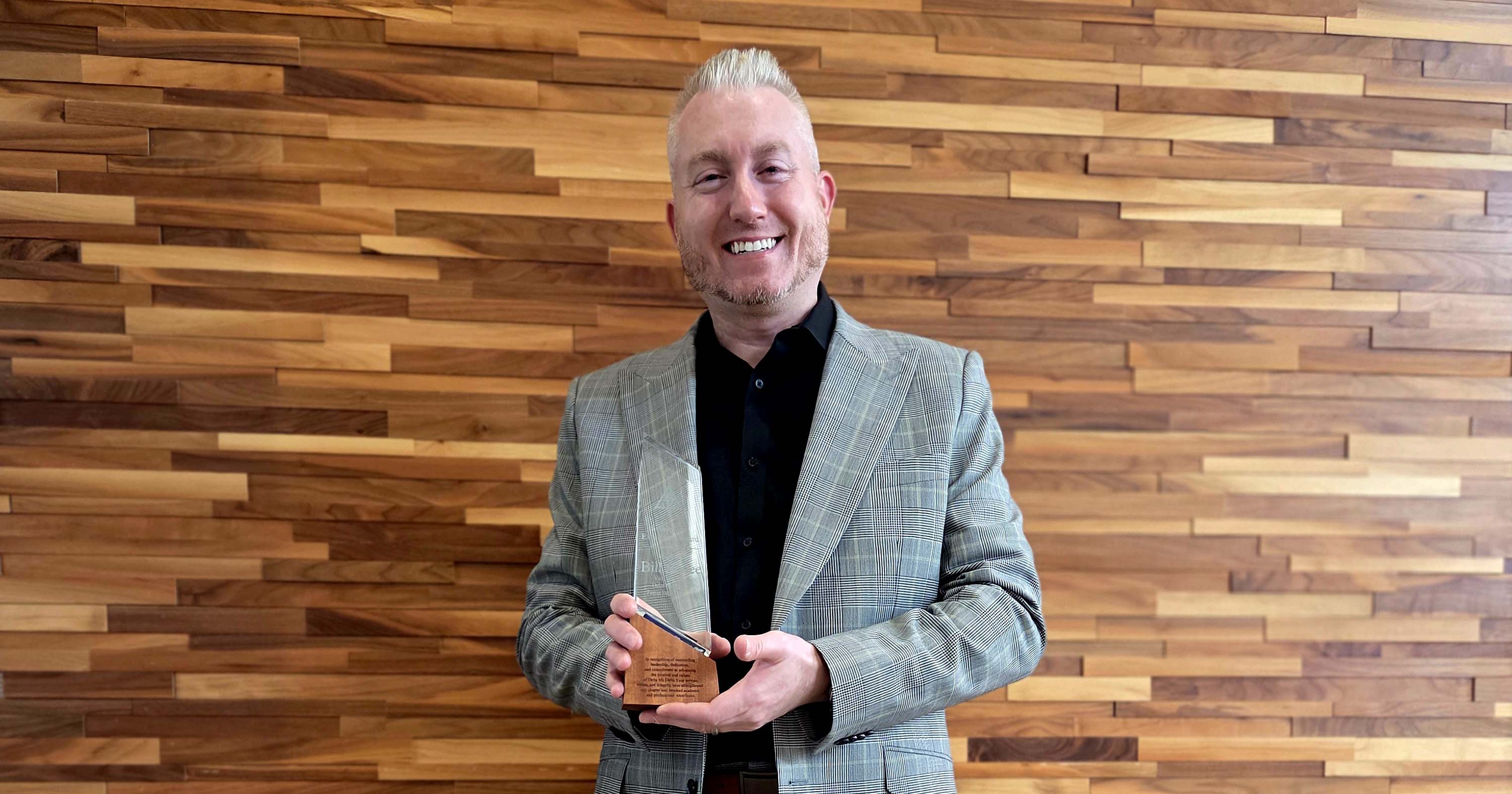 Bovee posing with an award from Delta Mu Delta