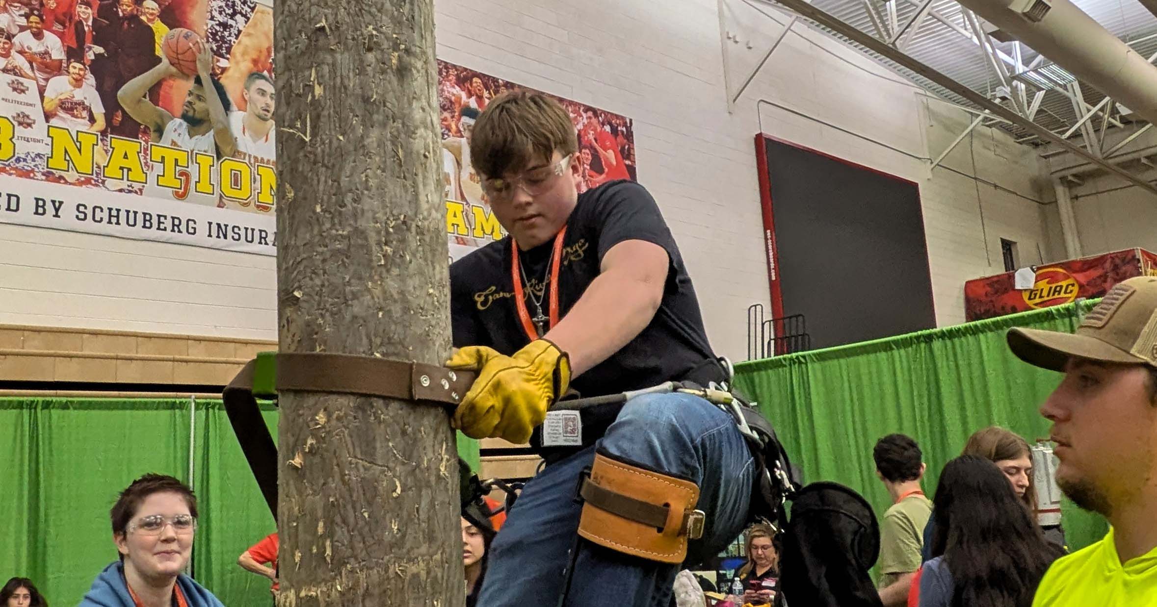 Student attempting to scale a faux utility pole