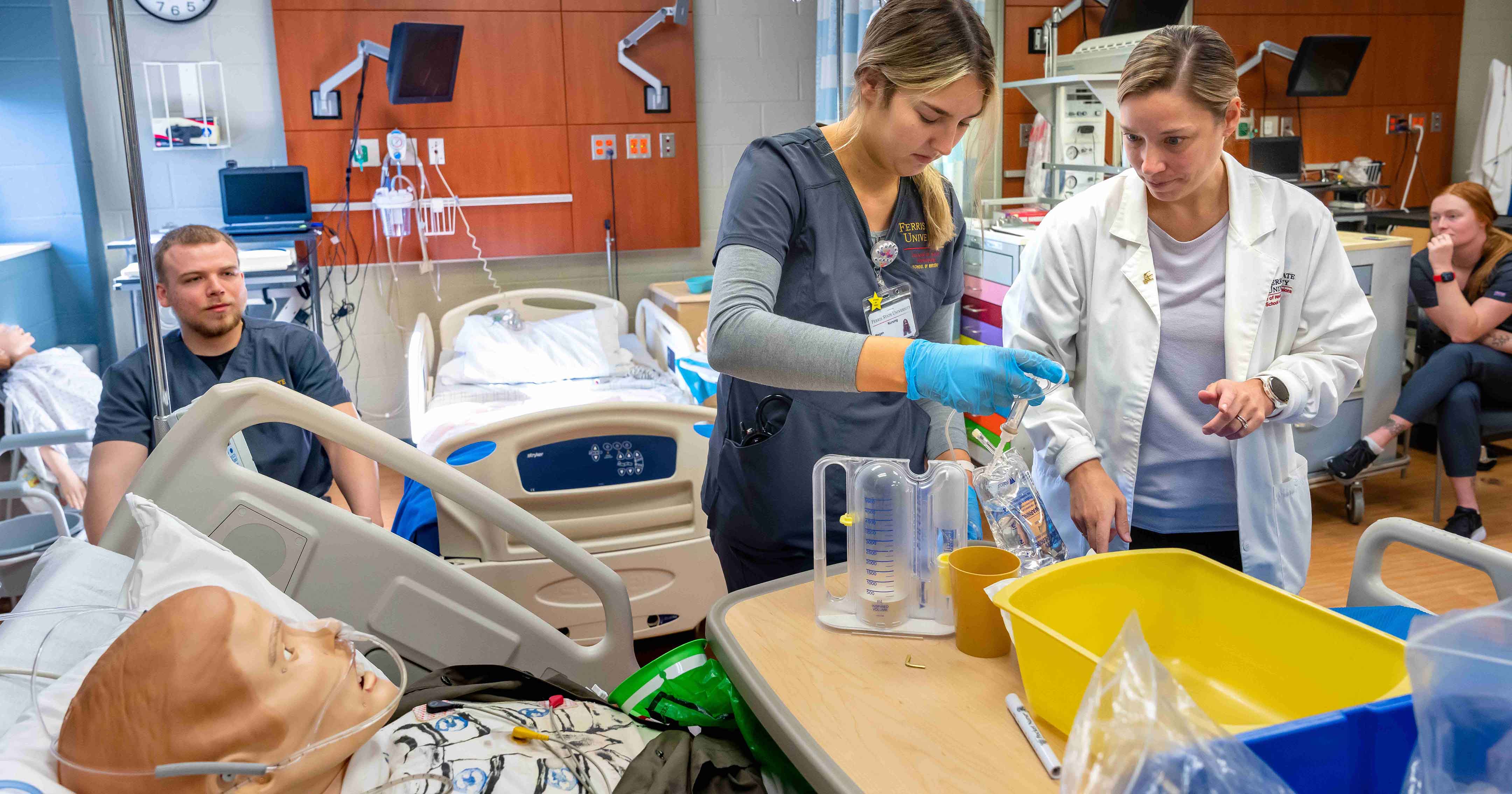Students in the College of Health Professions gaining hands-on experience through a nursing mannequin.