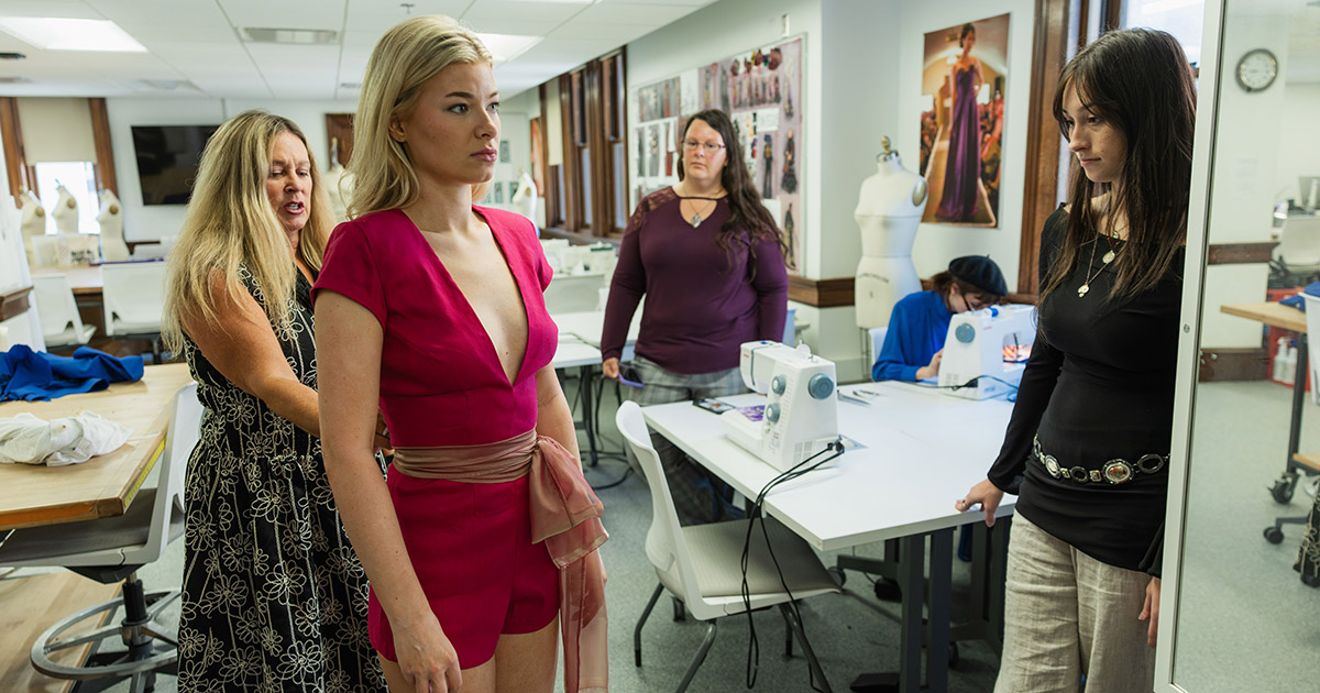 students fitting an outfit to a model