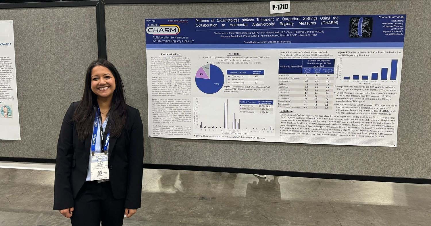 Nandi standing in front of her research during a CHARM convention in Los Angeles, CA.