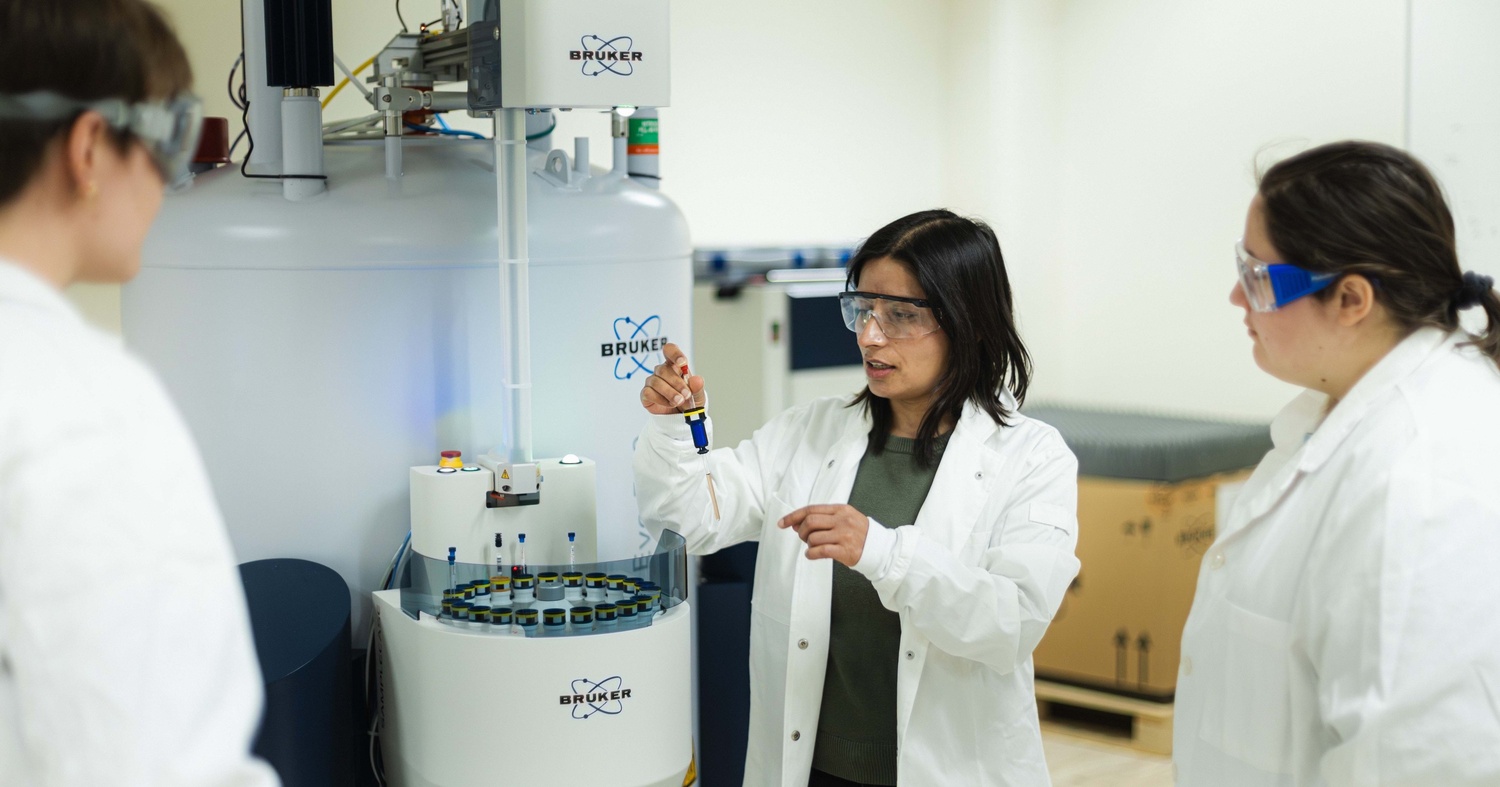 Dr. Khanal giving seniors Sophie Derusha and Senna Andrews a brief lecture about the NMR instrument