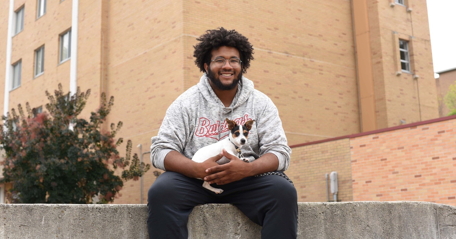 One of Crouch's portraits featuring Ferris State student Alando Steele holding his puppy