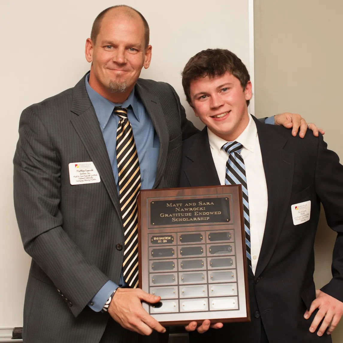student and faculty standing together with an award