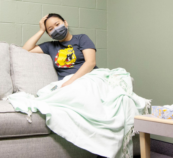 Student on a couch with a blanket