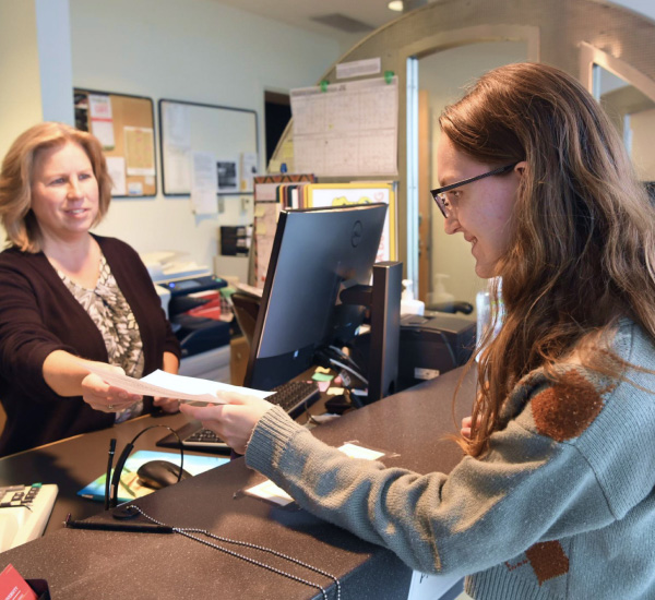 Student receiving a document from a worker in the financial aid office