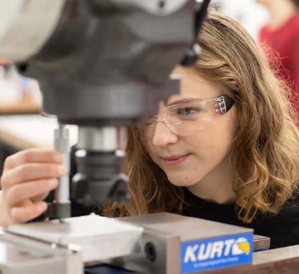 Student working with an industrial machine