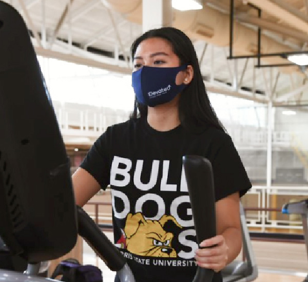 Student working out while wearing a mask