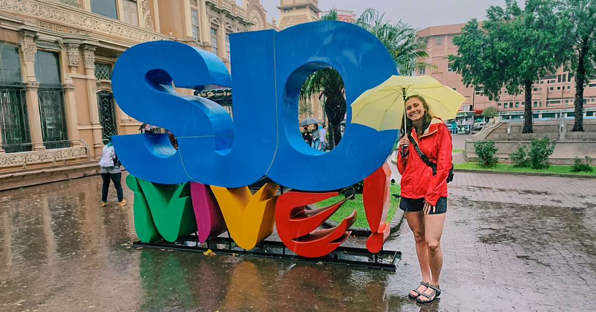 Ferris State University study abroad student studying in Costa Rica standing next to a sign