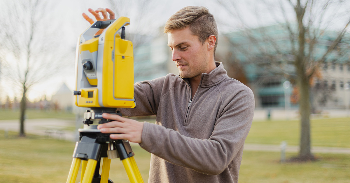 Ferris State University Surveying Engineering student using a theodolite during a lab.