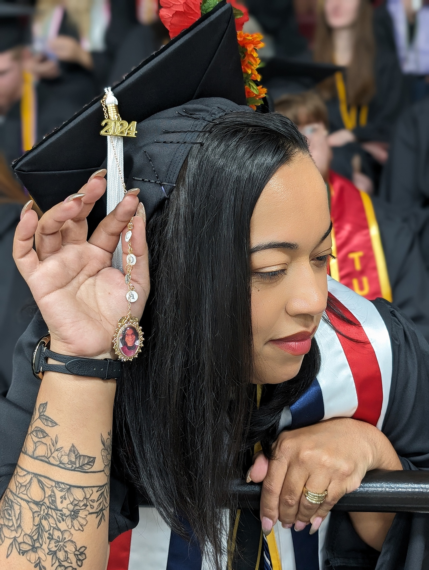 Massiel Calderon showing a photo of her grandmother attached to her tassel.
