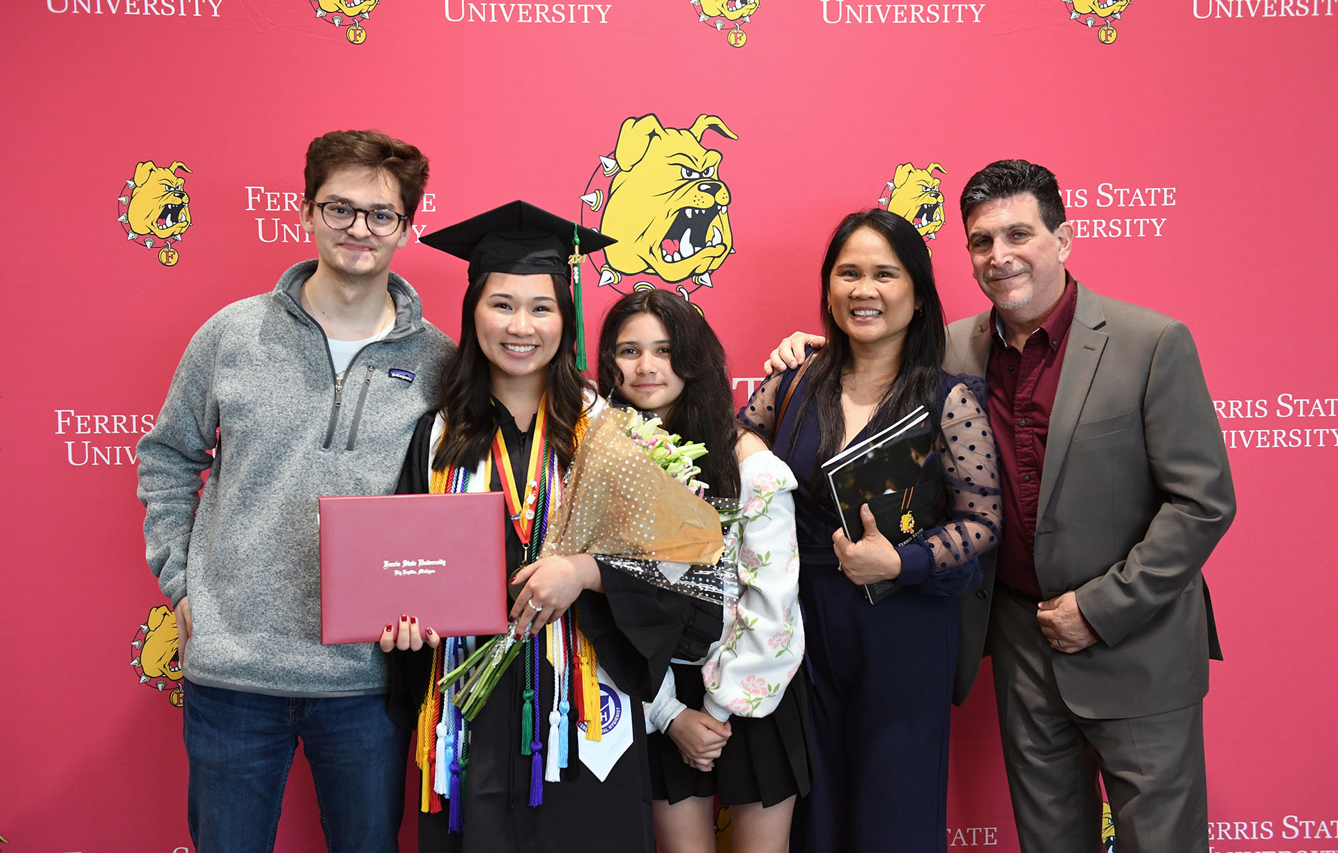 Kyla Buccini, a Dental Hygiene Ferris State graduate, poses with friends and family after commencement.