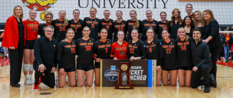 volleyball team photo in front of volleyball court