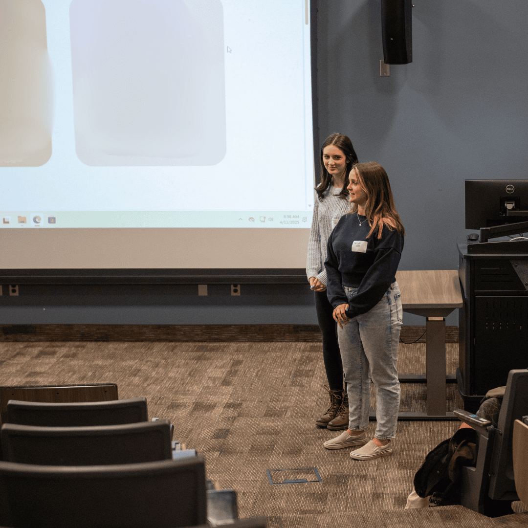 two woman in front of screen