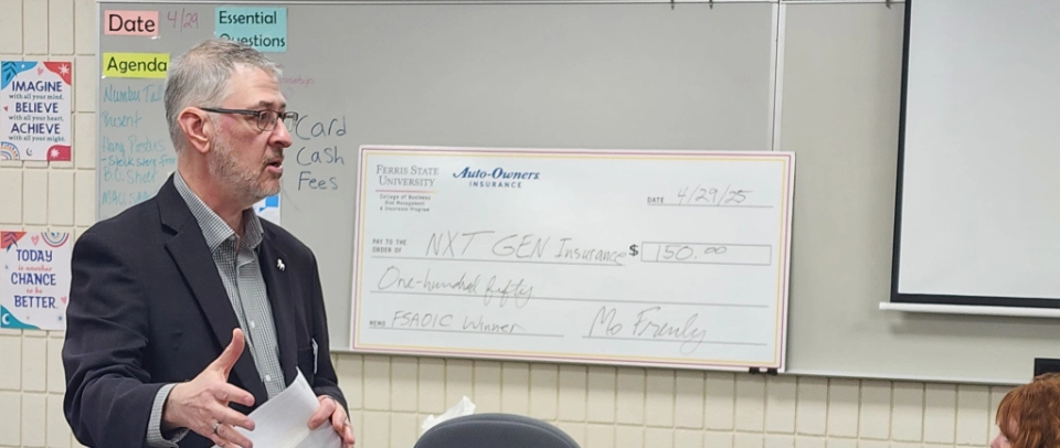 man in front of large check
