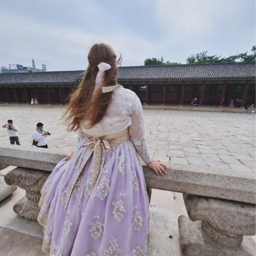 woman in formal korean dress overlooking a building