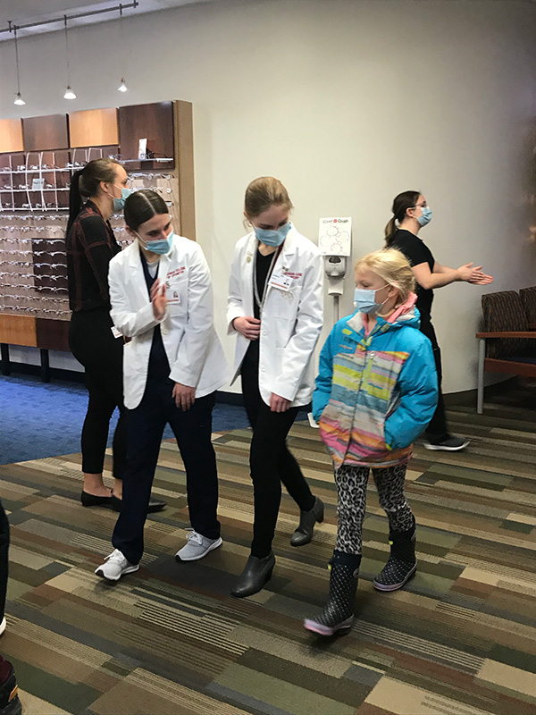 MCO students with a young patient