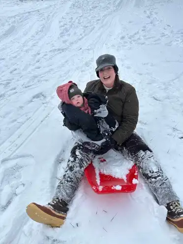Shannon McLean in sled with child