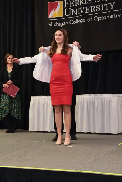 Student having a white coat put on them