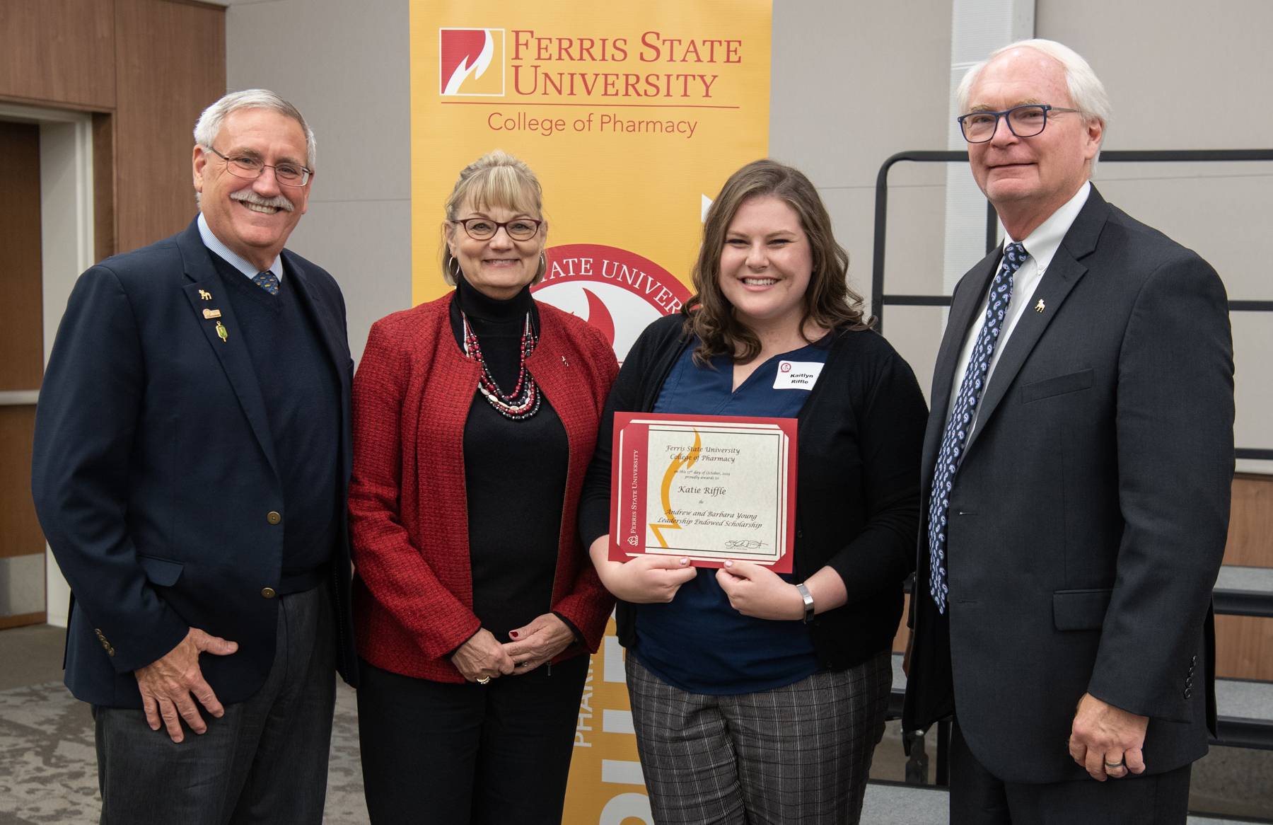 A student receiving her scholarship from the Dean and the scholarship sponsors