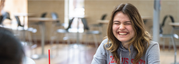 Student sitting at a computer and smiling.