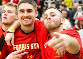 Two students in Ferris shirts. One is pointing at the camera