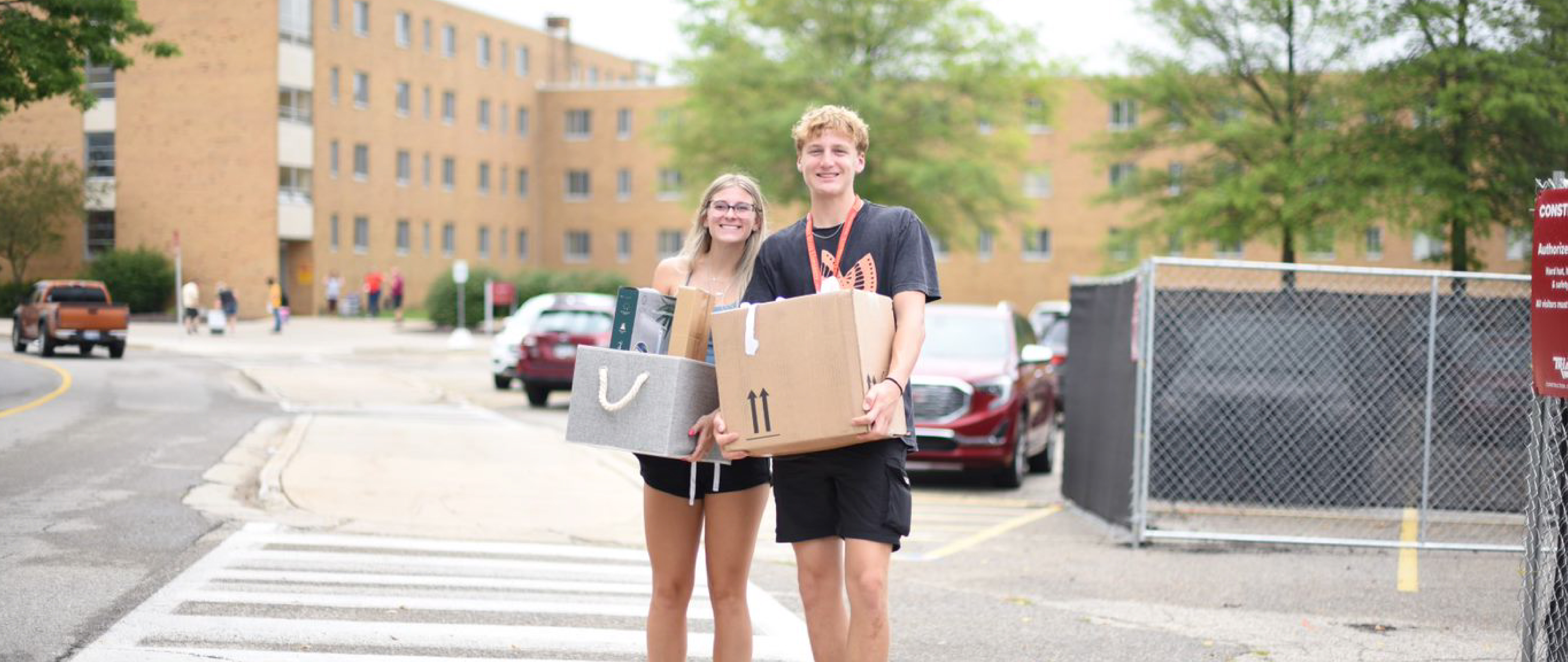 Two students carrying in boxes on move-in day