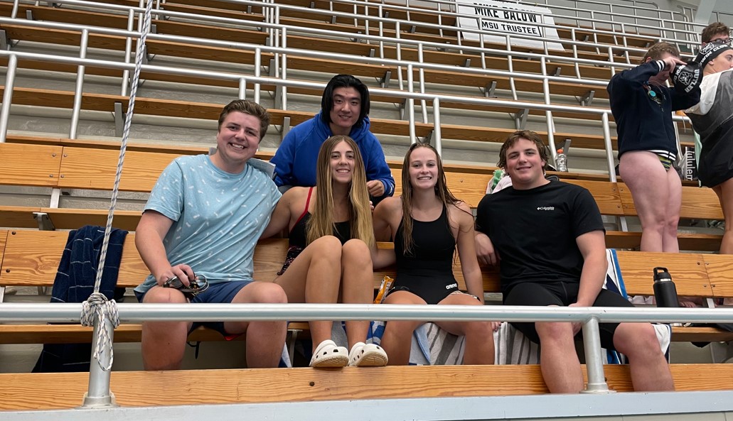 Swimmers sitting in the bleachers