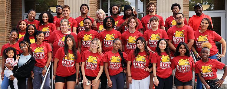 four students standing and smiling