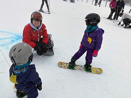 A group of young snowboarders speaking with a student