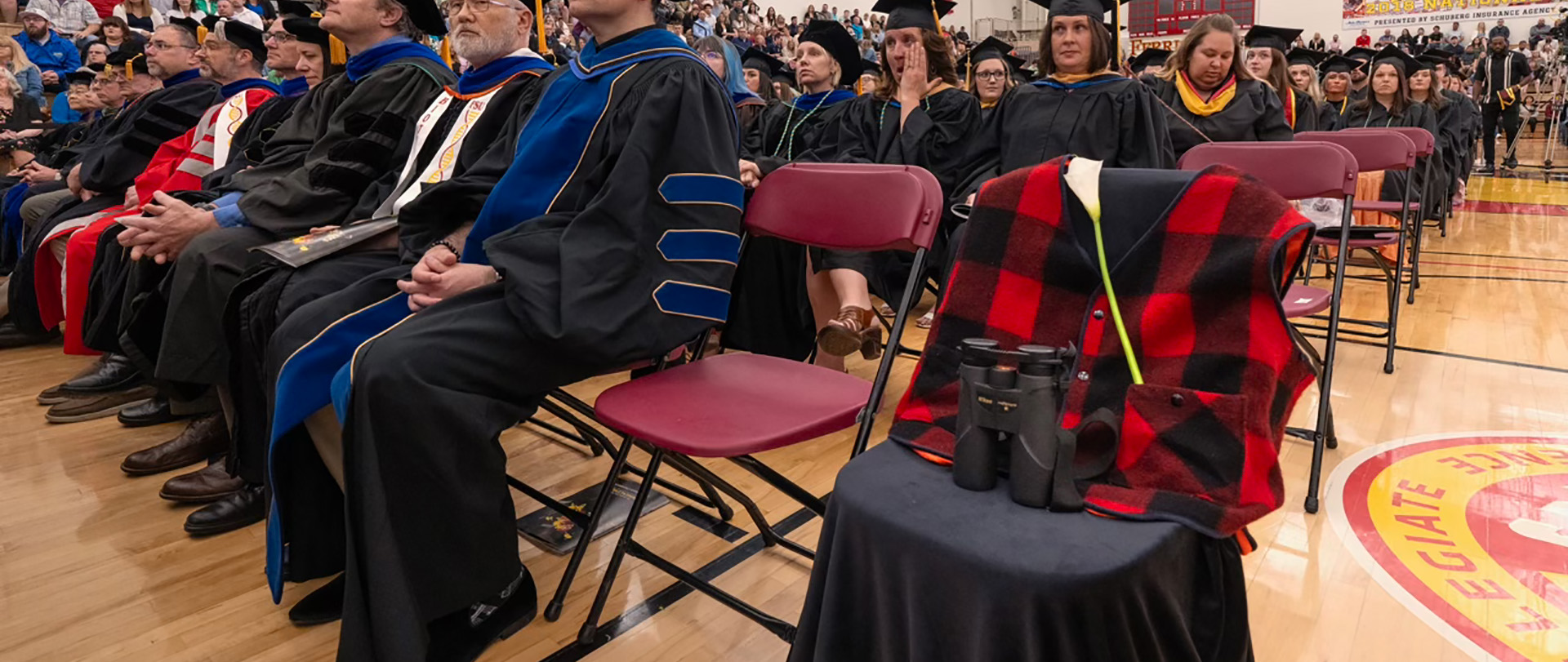 A chair is left empty at the Ferris State Commencement Ceremony for Professor Paul Klatt